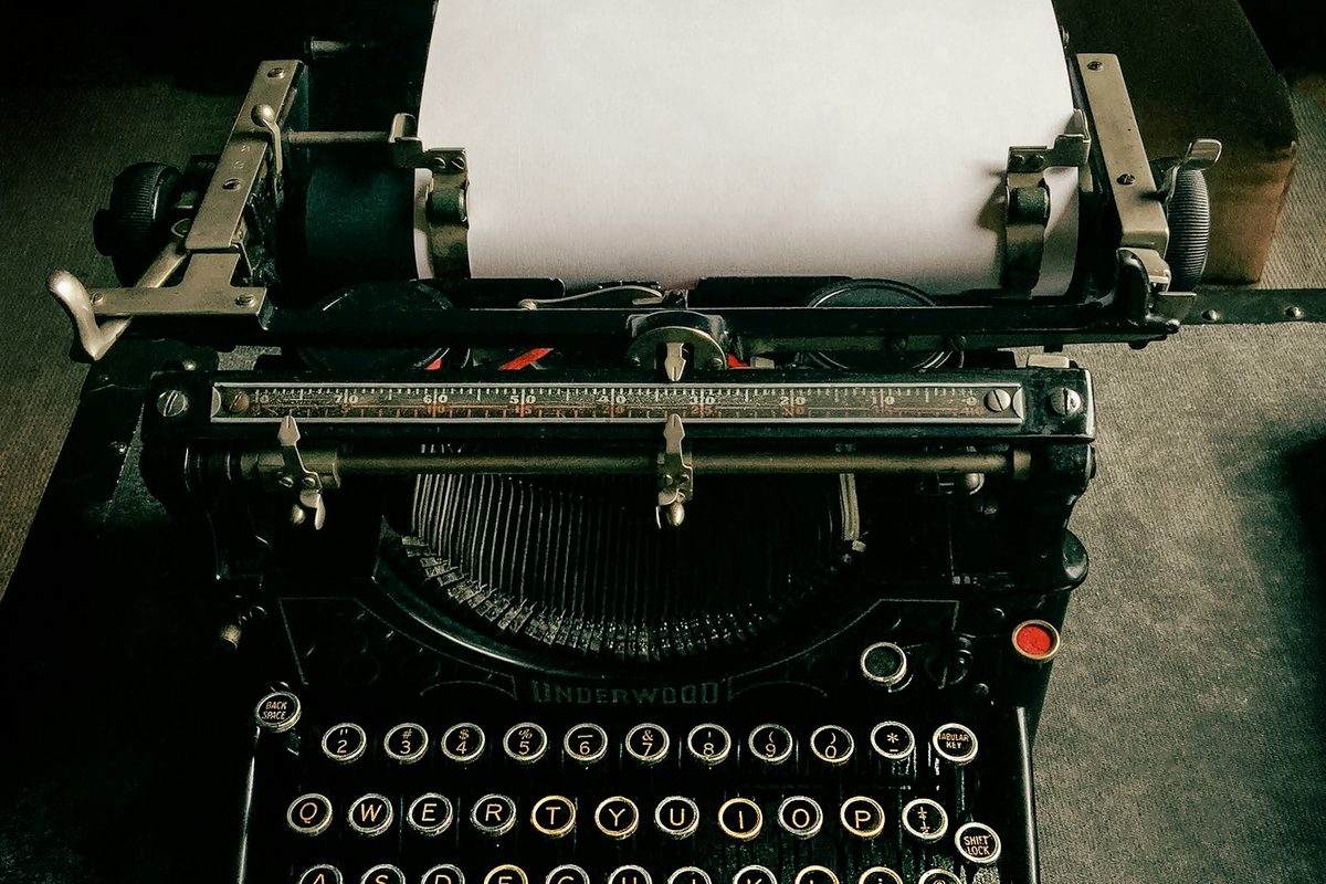 A vintage Underwood typewriter with a blank sheet of paper in the carriage