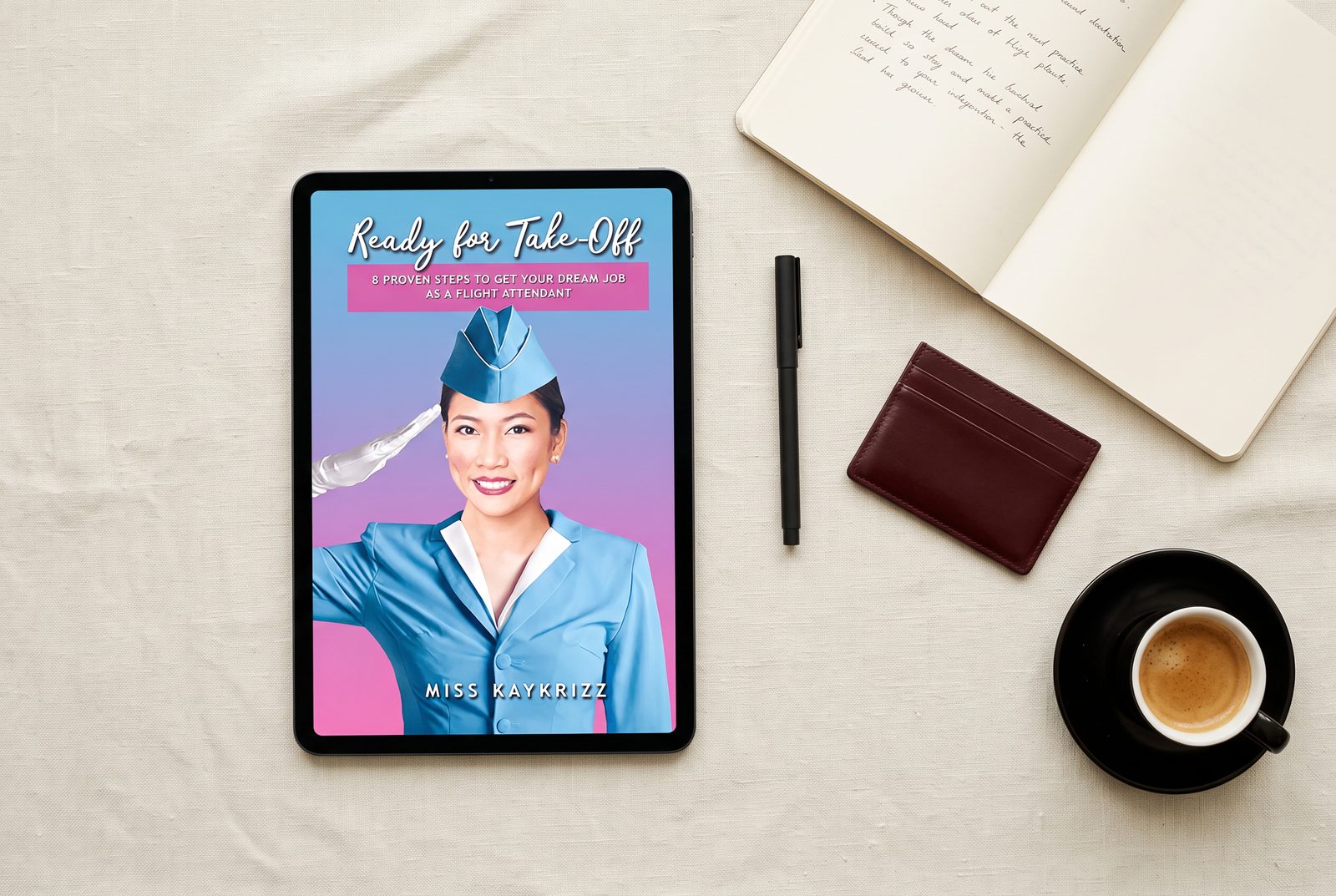 Ready for Take-Off ebook open on a tablet beside a notebook, pen and coffee