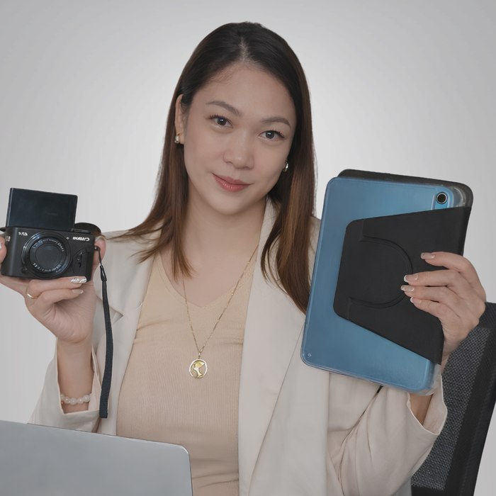 Ruth Maclang holding a camera and a tablet