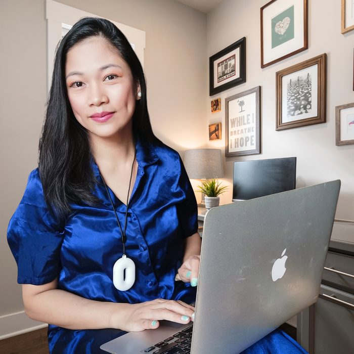 Ruth Maclang working on her laptop at her home desk